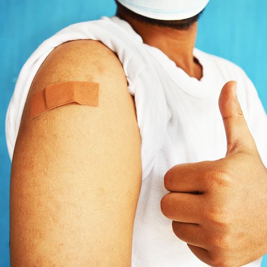 Vaccinated person gives thumbs up