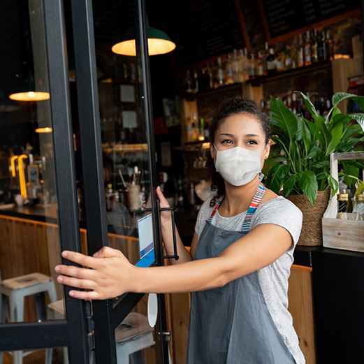 Woman in mask opens restaurant door
