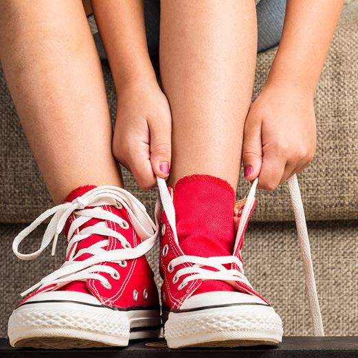 Child puts on red shoes