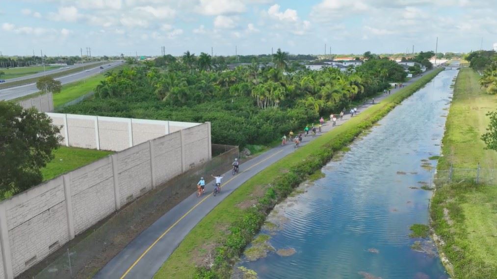 Bike riders on trail next to canal